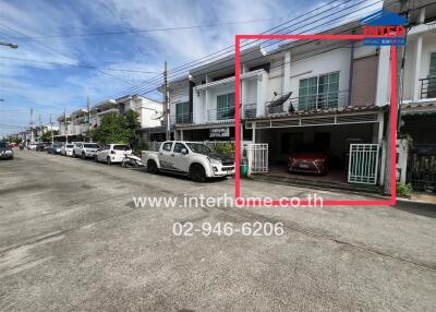 Two-storey residential townhouse with cars parked outside