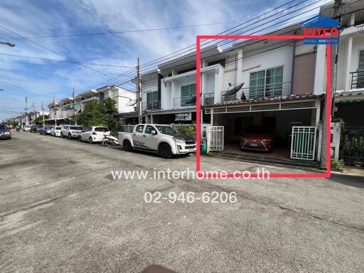 Two-storey residential townhouse with cars parked outside