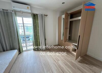 Spacious bedroom with an open wardrobe and balcony access