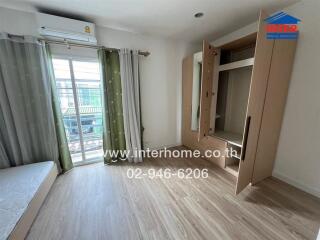 Spacious bedroom with an open wardrobe and balcony access