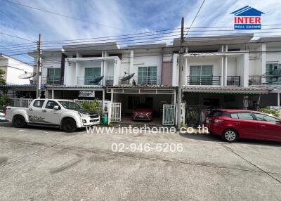 Front view of a residential building with parked cars