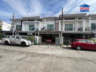 Front view of a residential building with parked cars