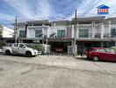 Front view of a residential building with parked cars