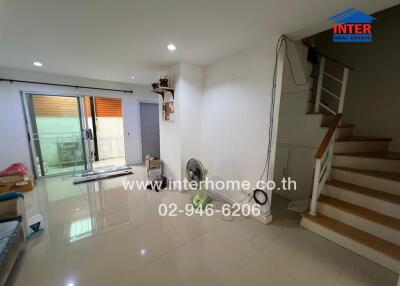 Living room with stairs and sliding door to balcony