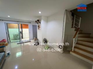 Living room with stairs and sliding door to balcony