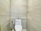 Minimalist bathroom with tiled walls and floor featuring a modern white toilet