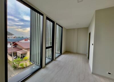 Modern room with large windows and a view of the neighborhood