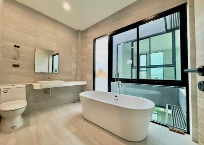 Modern bathroom with large window and standalone bathtub