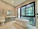 Modern bathroom with large window and standalone bathtub