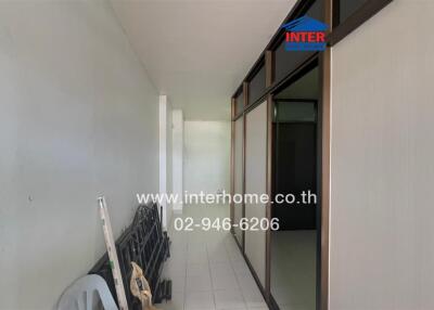 Narrow hallway with glass-paneled doors and storage