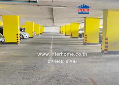 Indoor parking area with multiple parked cars and yellow pillars