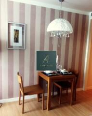 Cozy dining area with a small wooden table and two chairs, striped wallpaper