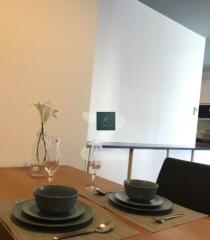 Dining table with place settings and vase with flowers