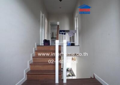 Staircase inside a house with wooden steps and white railings