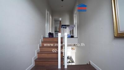 Staircase inside a house with wooden steps and white railings