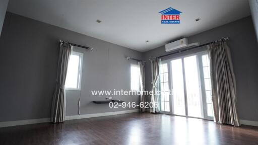 Spacious living room with large windows and air conditioning