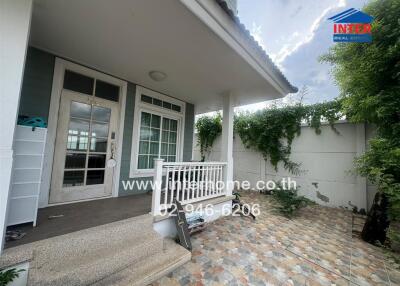 Front entrance of the house with porch and a tiled walkway