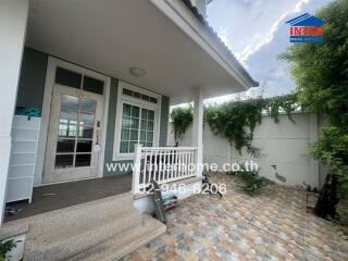 Front entrance of the house with porch and a tiled walkway