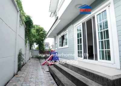 Side view of a house with a narrow tiled pathway