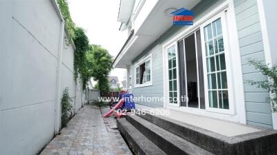 Side view of a house with a narrow tiled pathway