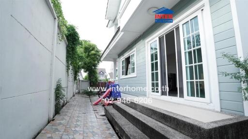 Side view of a house with a narrow tiled pathway