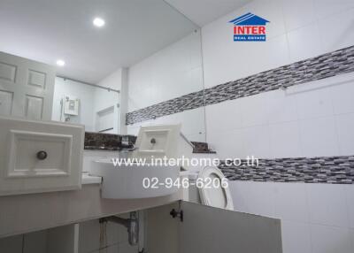 Modern bathroom with tiled walls and a large mirror