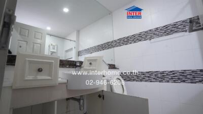 Modern bathroom with tiled walls and a large mirror