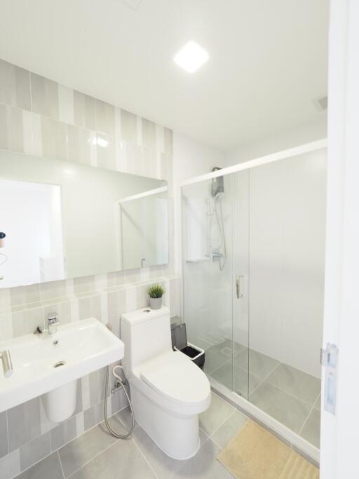 Modern bathroom with glass shower, toilet, and sink