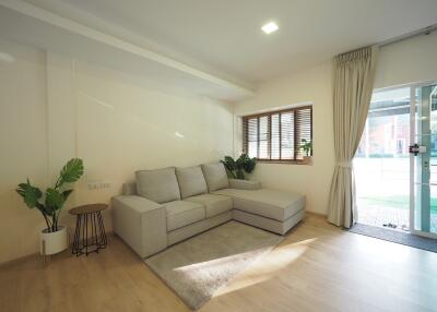 Well-lit living room with a sectional sofa and large windows