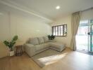 Well-lit living room with a sectional sofa and large windows