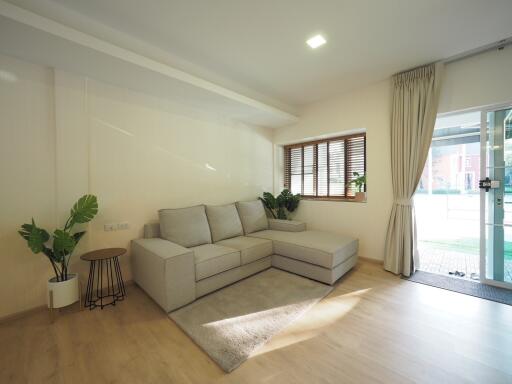 Well-lit living room with a sectional sofa and large windows