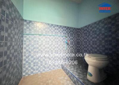 Bathroom with blue tiles and a toilet