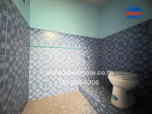 Bathroom with blue tiles and a toilet