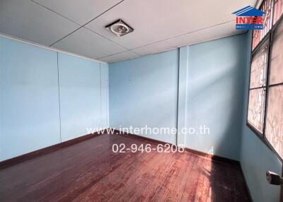 Bedroom with wooden floor and blue walls