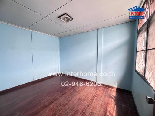 Bedroom with wooden floor and blue walls