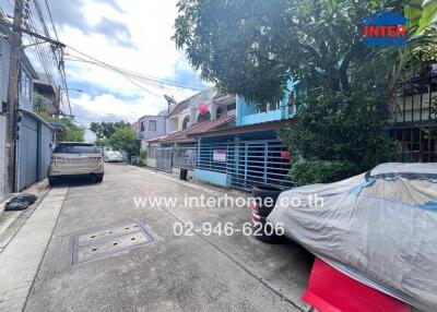 Street view of residential area with parked cars and houses