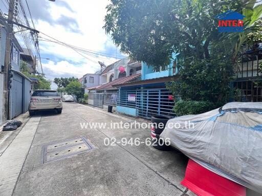 Street view of residential area with parked cars and houses