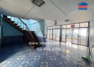 Spacious living area with stairs and large windows