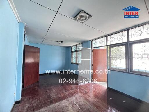 Bedroom with wooden flooring and blue walls