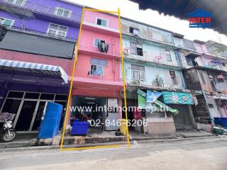 Exterior view of a multi-story residential building with a pink facade