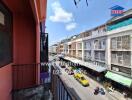 Outdoor view from a balcony overlooking a street with cars and buildings