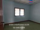 Empty bedroom with tiled ceiling and barred windows