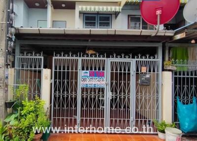 Exterior view of a townhouse with gated entrance