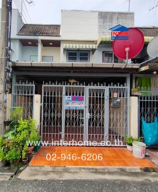 Exterior view of a townhouse with gated entrance