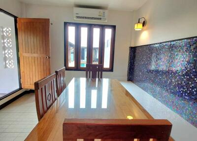 Dining room with wooden table and mosaic tile accent wall