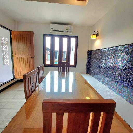 Dining room with wooden table and mosaic tile accent wall