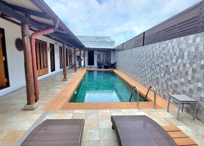 View of swimming pool with lounge chairs and patio area