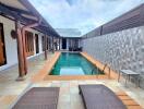 View of swimming pool with lounge chairs and patio area