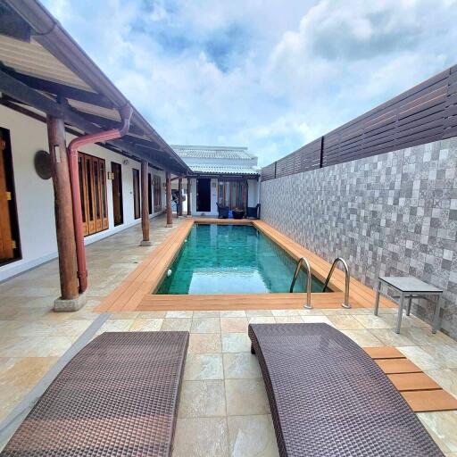 View of swimming pool with lounge chairs and patio area