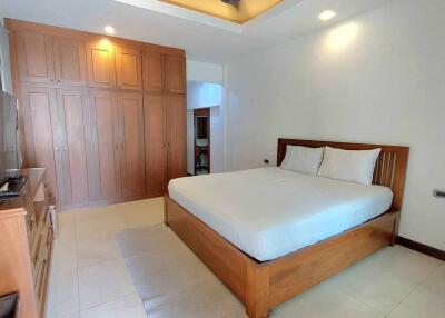 Master bedroom with wooden furniture and large wardrobe